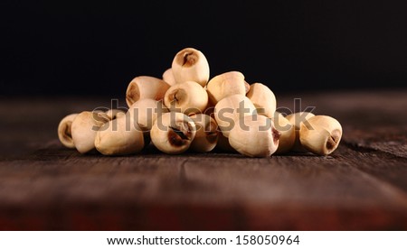 A group of dried lotus seeds on brown wooden table