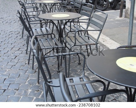 Tables awaiting guests in a restaurant on a coast of  the Italian  sea
