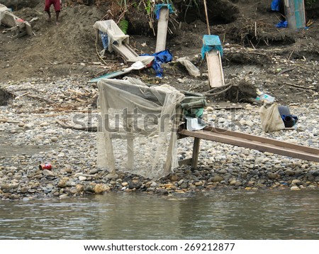 Jungle, Indonesia - January 13, 2015: A small compact structures with boards serve locals to wash out gold from the river sand