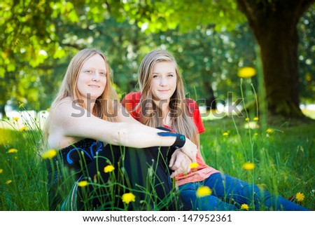 Mother and daughter in green summer nature. Shallow DOF, girl\'s face in focus.