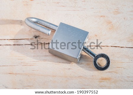 Silver Key and lock on wood background