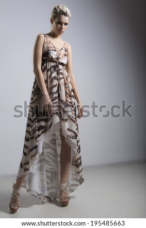 Beautiful blonde with short hair in a dress. posing in studio near light sources on a tripod
