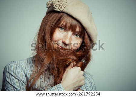 Portrait of a cute red-haired woman studio light background