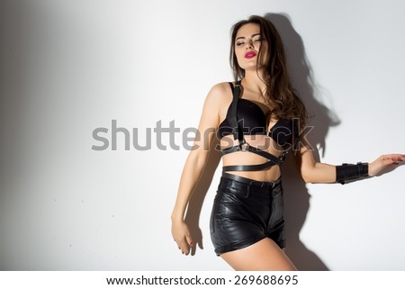 Sexy young woman in black erotic lingerie studio light background