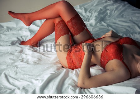 Attractive girl\'s legs in red lace lingerie stockings