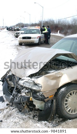 Police investigate a car wreck on an icy road.