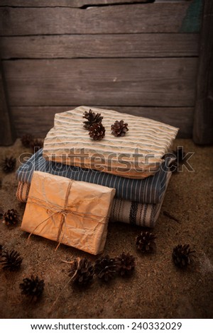Pile of clothes with a pine cones and gift on wooden background