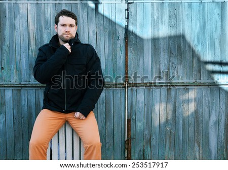 the Hipster style guy. Fashion man near a wooden door