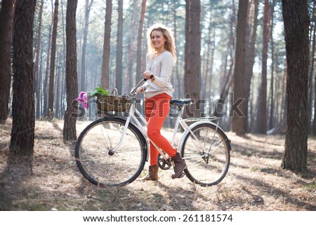 Beautiful young woman on bike in park