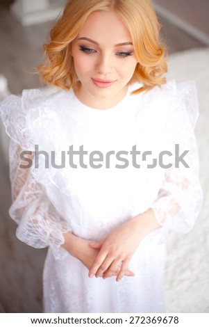 portrait attractive blonde woman in a white dress with lace, top view