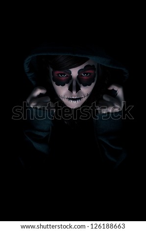 Low key portrait of young woman with sugar skull make-up