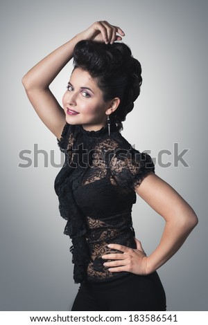 Attractive young woman with professional make-up and hair style. Posing in short beautiful dress. With handmade jewelry.