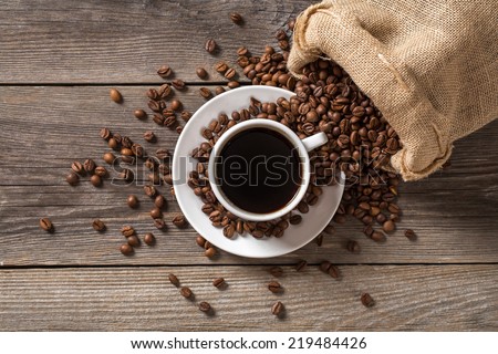 Coffee cup with coffee bag on wooden table. View from top.