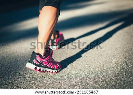 Sporty woman running on road at sunrise. Fitness and workout wellness concept.