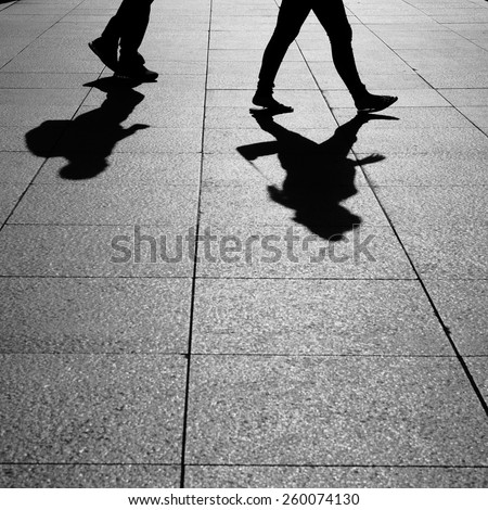 Shadows of people walking in a street of the city