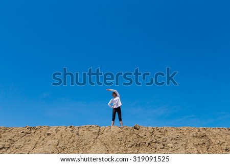 A Young Woman With Arms Stretched Out To The Sky Stock Photo