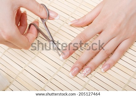 woman cuts nails scissors, close up.