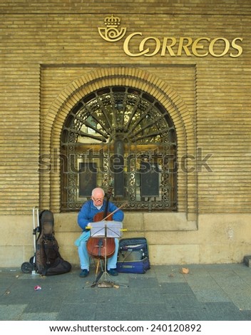 ZARAGOZA, SPAIN, NOVEMBER 1, 2014: old man is playing bass in front of the post office in spanish city zaragoza.