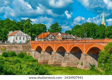 Similar – Foto Bild Kleiner Fluss in einem lettischen Wald, aufgenommen von einer Brücke. Das Wasser ist mit Wasserpflanzen bewachsen, viele Grüntöne und einige Gelbtöne. Frühherbst Landschaft, bewölkten grauen Himmel