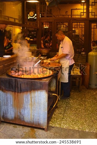 BEIJING, CHINA, AUGUST 21, 2013: chinese cook is preparing some local specialty in his stand in dashilar quarter in beijing.