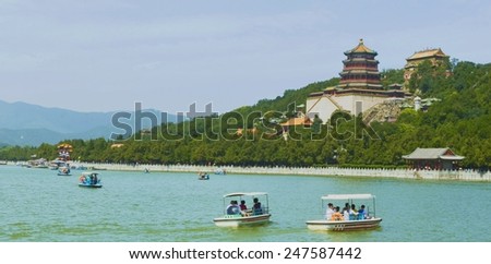 BEIJING, CHINA, AUGUST 15, 2013: People are driving pedal boats on the lake inside new summer palace complex in beijing.