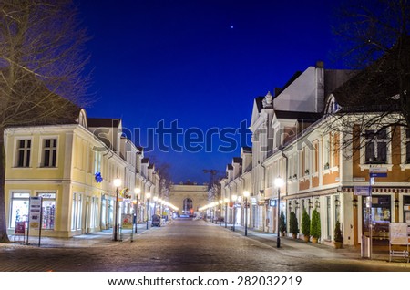 POTSDAM, GERMANY, MARCH 11, 2015: night view of illuminated main alley in potsdam - brandenburger strasse. At one end is situated brandenburger tor and at the second saint peter and paul church.