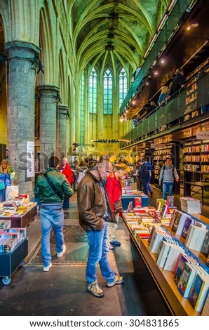 MAASTRICHT, NETHERLANDS, APRIL 12, 2014: People are buying books in bookshop which is situated in former church in maastricht.