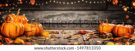 Mini Thanksgiving Pumpkins And Leaves On Rustic Wooden Table With Lights And Bokeh On Wood Background - Thanksgiving / Harvest Concept