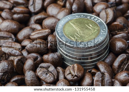 Coin stack growing up among coffee beans