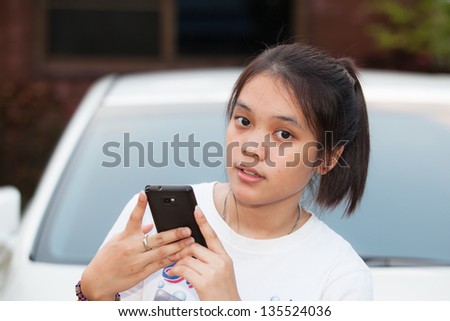 Young girl hold mobile phone in her hand with out focus background