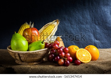 Still life fruits, fresh fruit display in wooden basket and some place on sack cloth