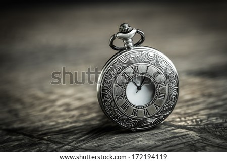 Vintage Antique pocket watch on grunge wooden background