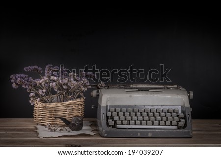 Still life, old typewriter and smoking pipe with dry flower on wooden desk