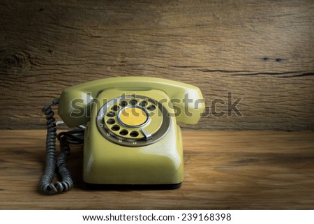 Still life with old green telephone on wooden table