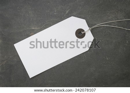 Blank white paper tag on stone surface