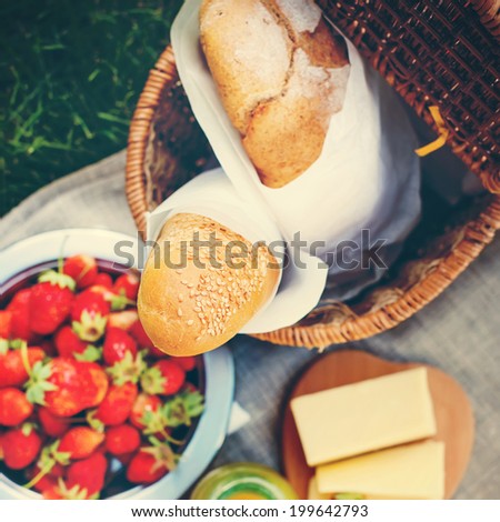 Picnic Food. Fresh Bread, Strawberry, cheese and  honey on a sacking cloth, selective focus, toned