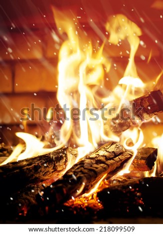 Magic Effect of falling Snow, on a Background Flame of Fire in a Fireplace