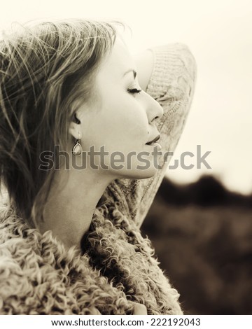 Young Beautiful Woman with Closed Eyes in Profile Listening a Silence, outdoor, toned in sepia