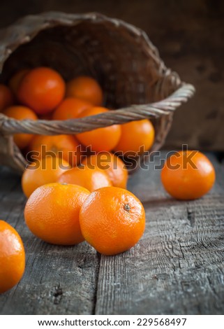 Basket and Tangerines on Wooden Background. Russian tradition to eat fruits at New Year