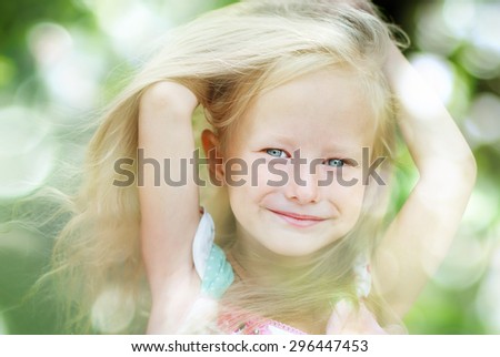 Happy Little Smiling Girl with Blonde Hair in Summer Park. Toned image