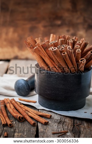Cinnamon Sticks in a Stone Mortar on Wooden Table, rustic style