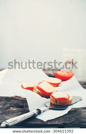 Fresh Sandwiches with Bread, Tomato and Cheese on the wooden table. Vintage style. Toned in Cold Colors. Image with Selective focus