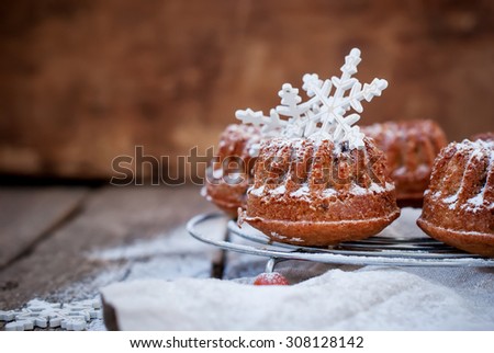 Small Baked Cake Decorated with White Snowflakes Dusted with Icing Sugar on Wooden Background