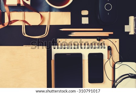 Set for Business Men with Black and Beige Accessories on office wooden table. Devices Phone, Tablet, Earphones. Top view toned