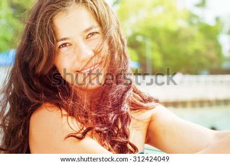 Smiling Happy Woman On Green Background in Park an Sunlight. Summer day