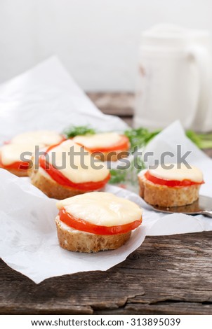 Little Sandwiches with Bread, Tomato, Cheese Baked in an Oven on Wooden Table. Simple snack
