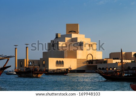 DOHA, QATAR - NOV 15: Dhows are anchored in the port beside the Museum of Islamic Art on Nov 15, 2013 in Doha, Qatar. The Museum is arguably Doha\'s most prized architectural icon