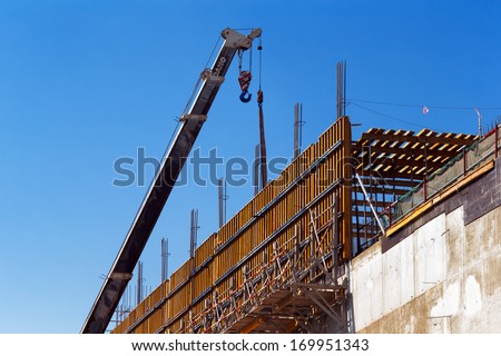 DOHA, QATAR - NOV 13: A mobile crane is poised to lift reinforced concrete shuttering on Nov 13, 2013 in Doha, Qatar. Doha, is preparing it\'s infrastructure for the World Cup in 2022