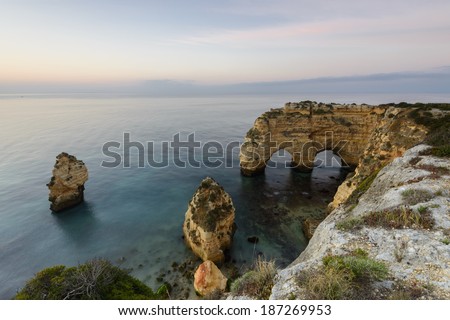 Landscape of the South Coast of Portugal at Sunrise. Marinha Beach is a holiday destination for its beautiful beaches with cliffs and hot water. The arch carved in stone is an amazing senary