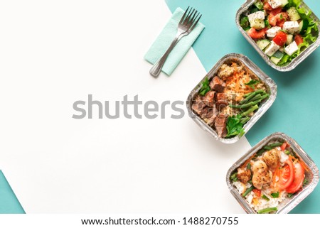 Healthy food delivery. Take away of organic daily meal on blue, copy space. Clean eating concept, healthy food, fitness nutrition take away in foil boxes, top view. ストックフォト © 